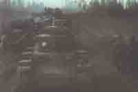 Колонна танков Pz Kpfw 38 (t) из 7-й танковой дивизии Вермахта проходит мимо разбитой советской техники и пленных красноармейцев. Осень 1941 г.